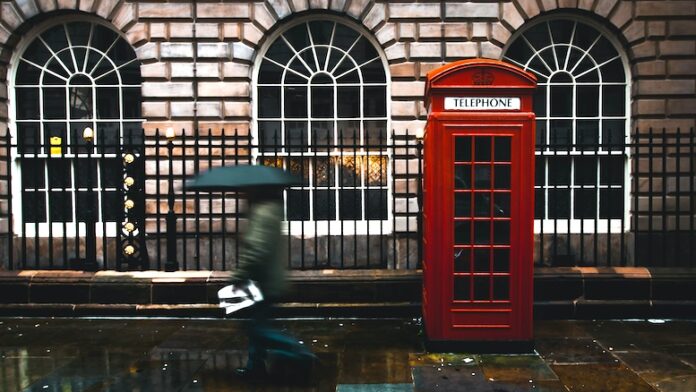 UK-red-telephone-box-payphone-rain-umbrella-city-street